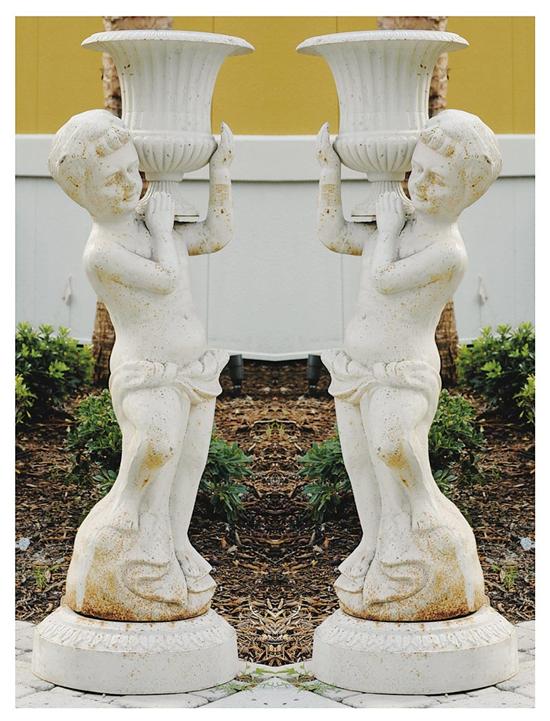 Appraisal: Pair cast-iron figural garden stands standing cherubs holding urns aloft