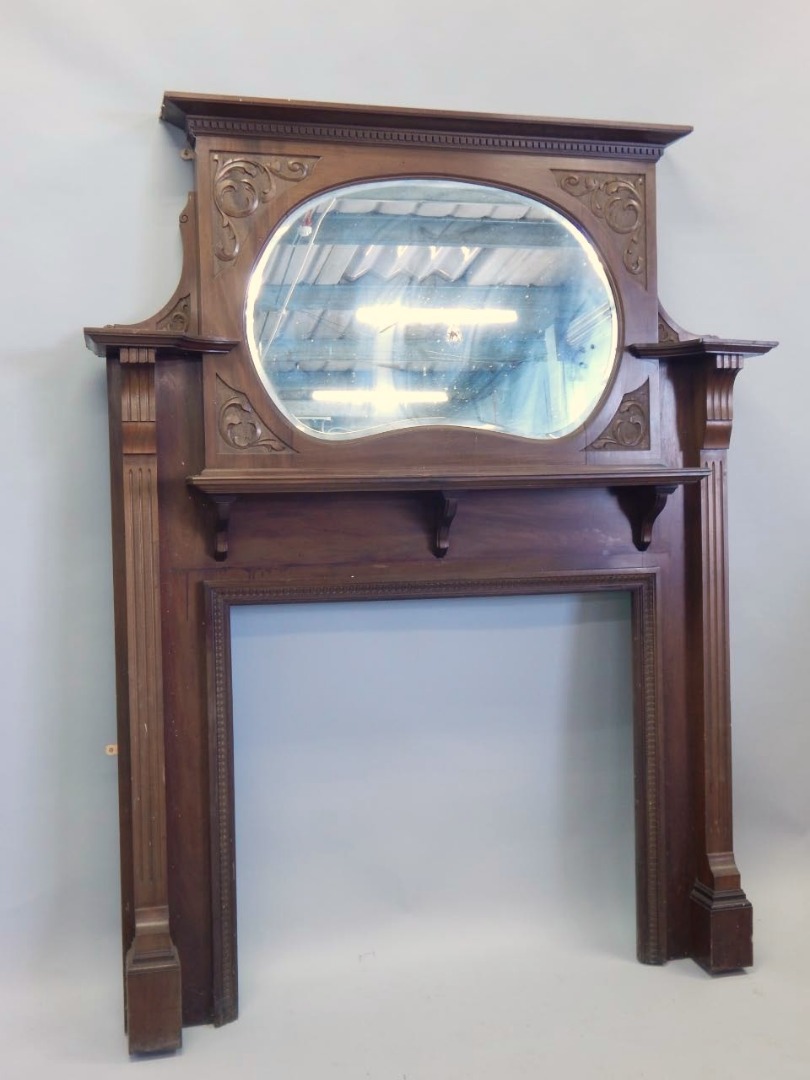 Appraisal: An Edwardian walnut fire surround the raised back with a