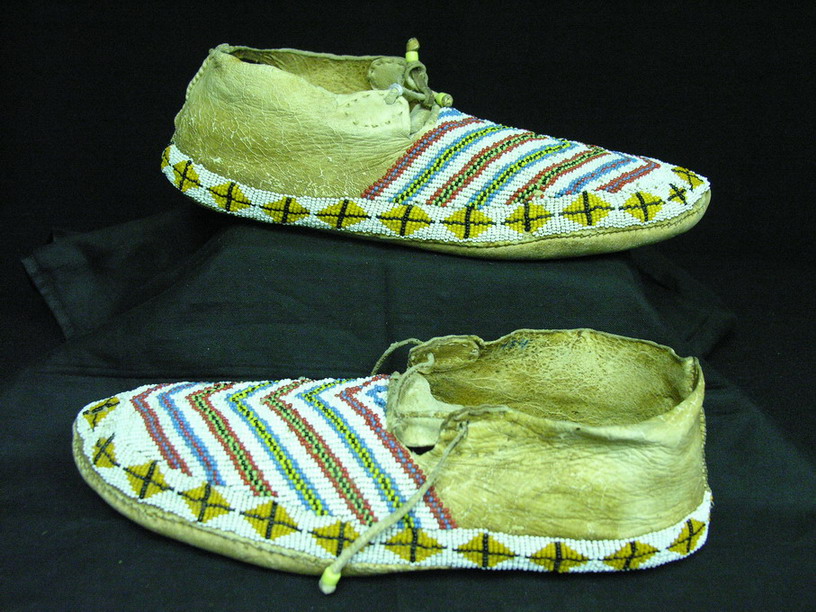 Appraisal: NATIVE AMERICAN BEADED MOCCASINS Chevron beaded design with geometric border