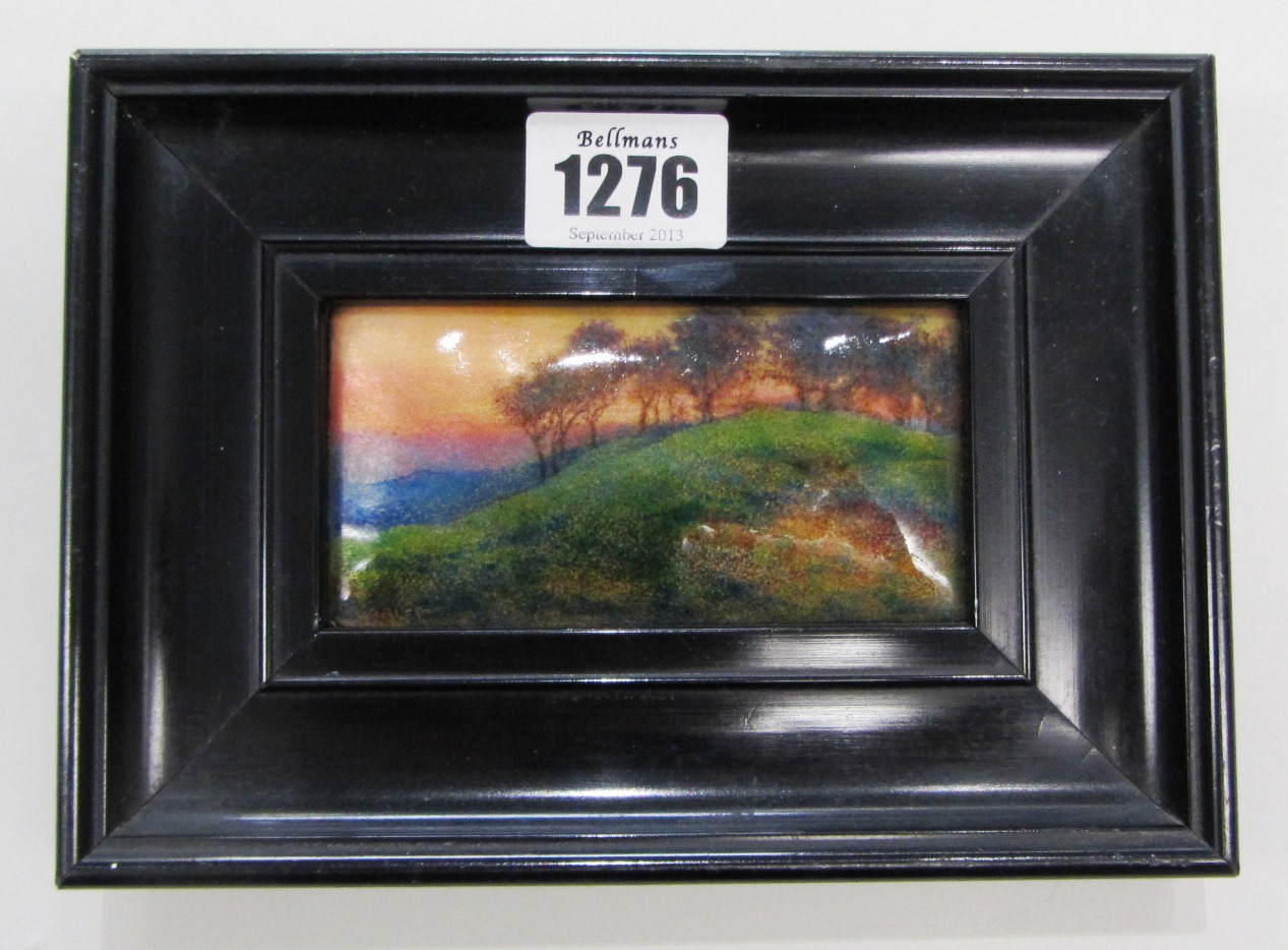 Appraisal: A rectangular enameled plaque designed as a wooded hilly landscape