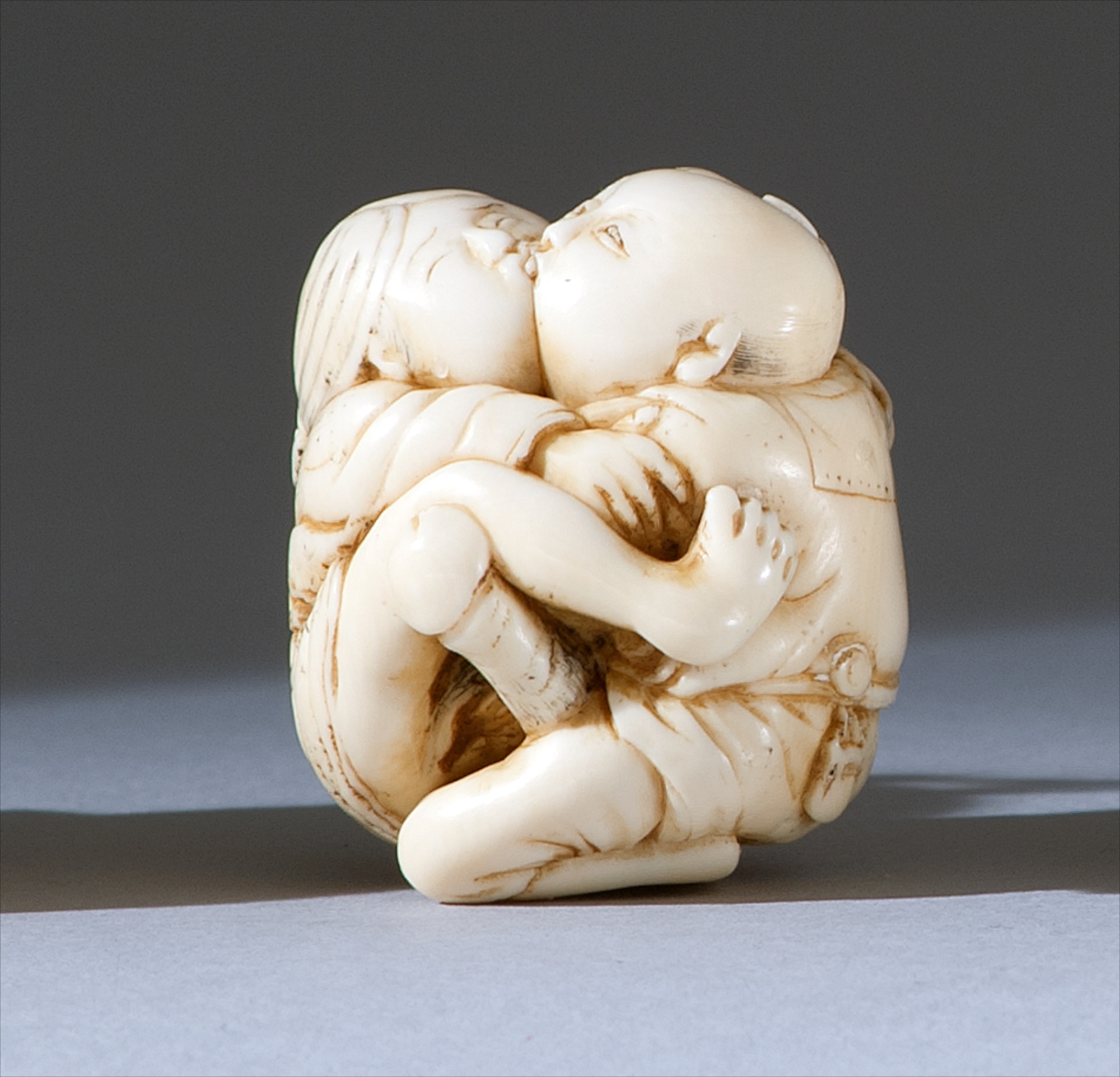 Appraisal: IVORY SHUNGA NETSUKE Meiji PeriodDepicting an intimate couple embracing Distinctive