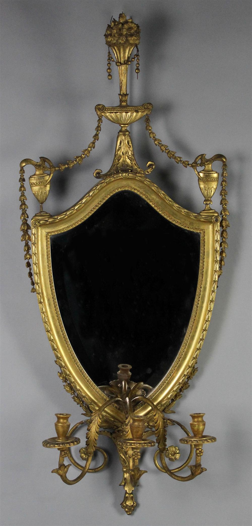 Appraisal: NEOCLASSICAL GILT MIRROR the shield shaped plate enclosed by garland