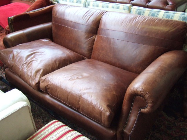 Appraisal: A th century leather sofa with scroll arms and button