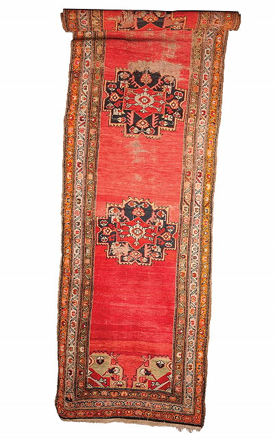 Appraisal: A TURKISH RED GROUND RUNNER with three central medallions and