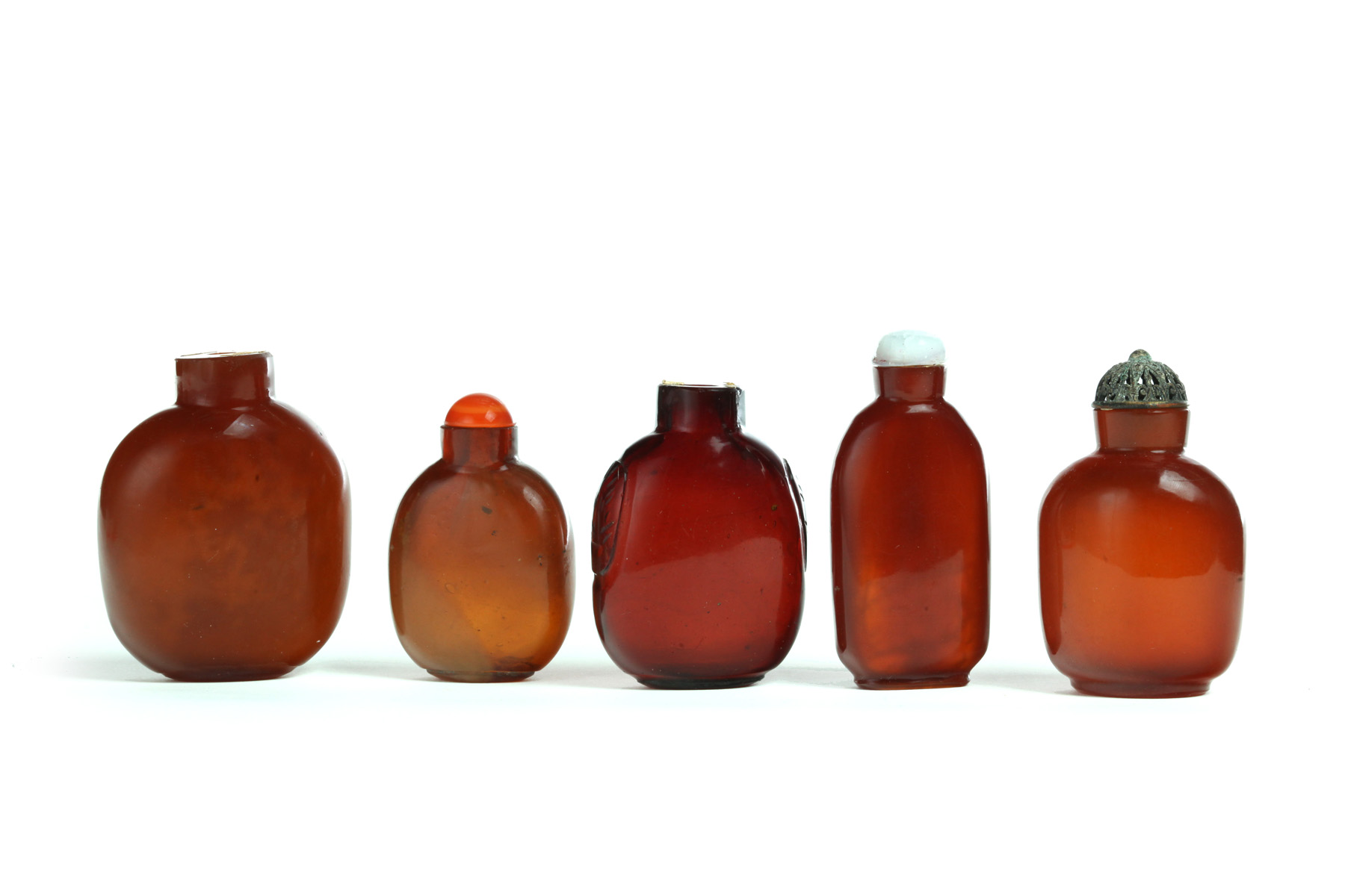 Appraisal: FIVE SNUFF BOTTLES China th century Four are amber colored