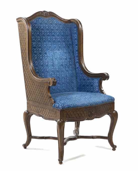 Appraisal: A French Provincial Style Wingback Armchair having a foliate carved