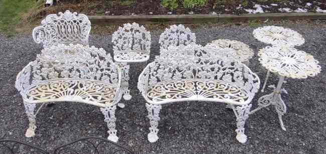 Appraisal: Cast iron grape pattern patio set consisting of two benches