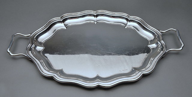 Appraisal: A SILVER TWO HANDLED TEA TRAY of shaped oval form