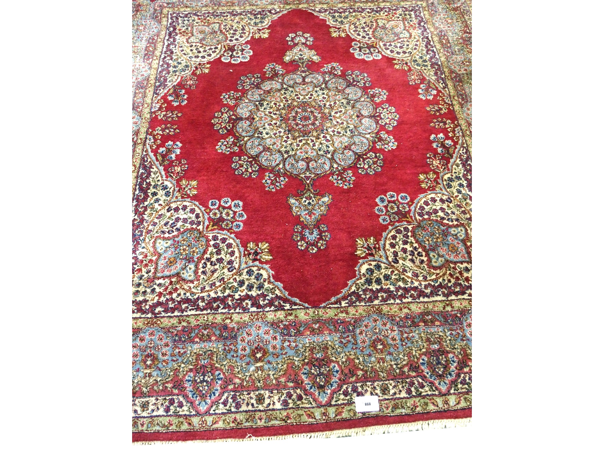 Appraisal: A Persian rugwith central red ground medallion within a multi-coloured