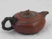 Appraisal: A Chinese ceramic Yixing teapot finely modelled and detailed as