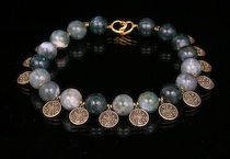 Appraisal: A Heavy Bead Necklace with Metal Charms Large carved green