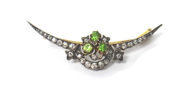 Appraisal: A demantoid garnet and diamond set brooch designed as a