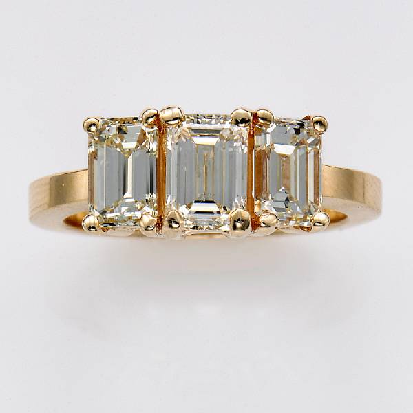 Appraisal: An emerald-cut diamond and fourteen karat gold three stone ring