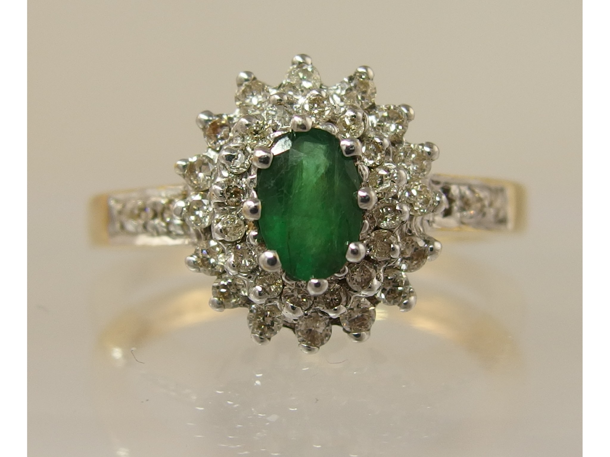 Appraisal: An ct yellow gold emerald and diamond cluster ringthe oval