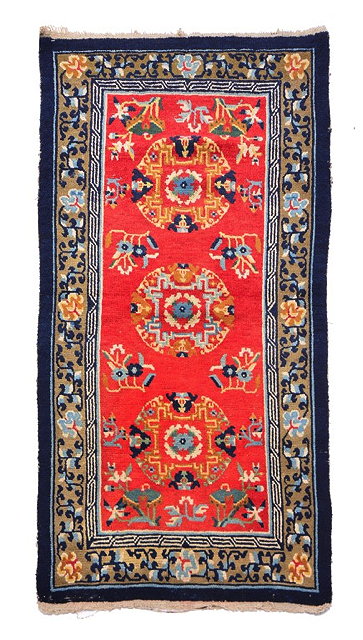 Appraisal: A TIBETAN RED GROUND RUG with all over stylistic decoration