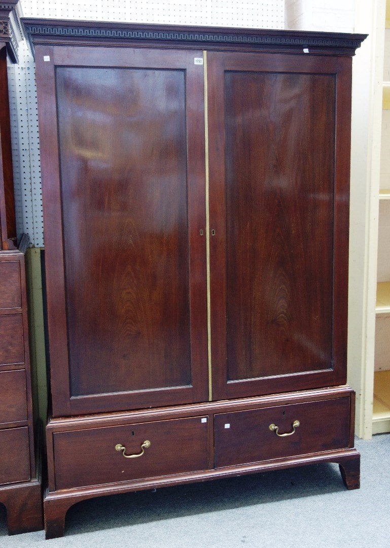 Appraisal: A George III mahogany wardrobe the dental carved cornice over