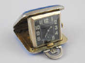 Appraisal: A miniature silver travelling bedside clock with enamelled engine turned