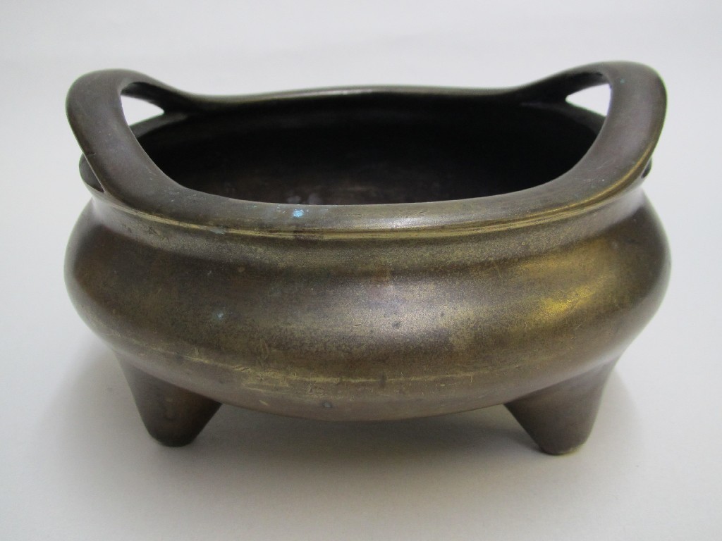 Appraisal: A Chinese bronze ting with curved handles on tripod base