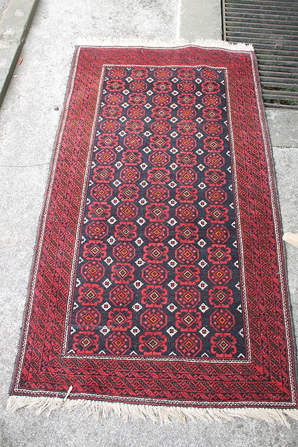 Appraisal: A PAKISTAN BLACK GROUND SMALL RUG with central rose of