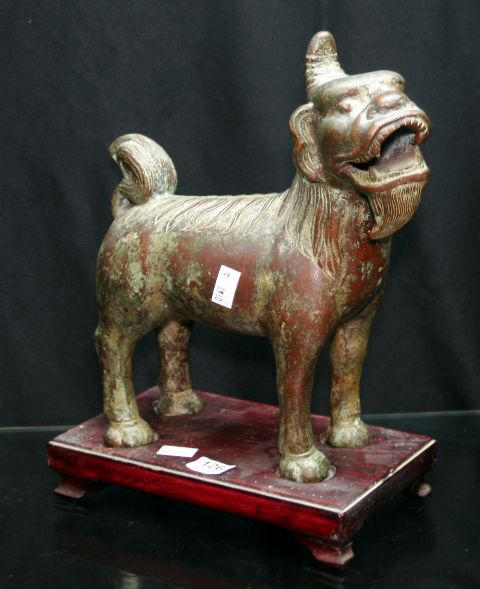 Appraisal: A Chinese bronze temple lion on wooden stand possibly late