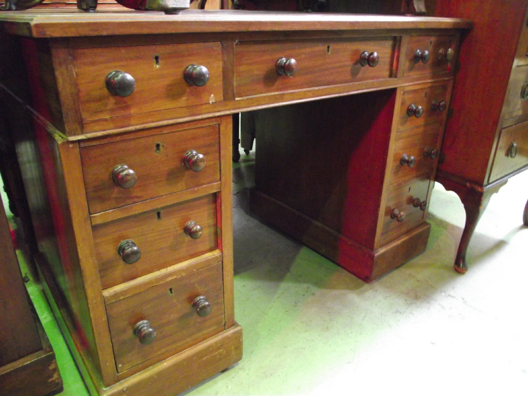 Appraisal: A Victorian mahogany kneehole twin pedestal writing desk with worn