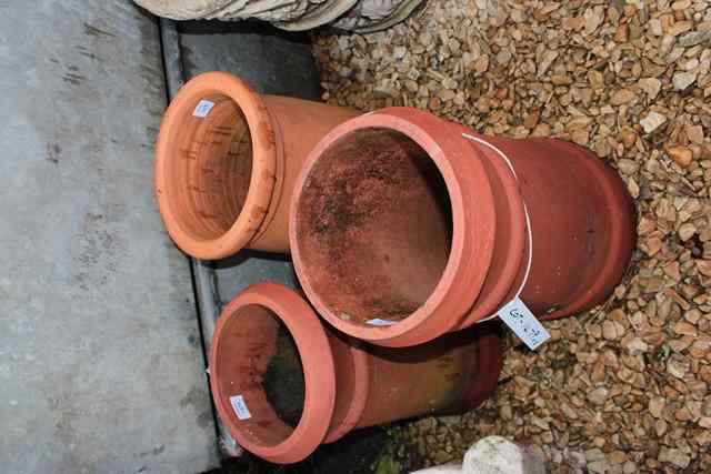 Appraisal: THREE OLD RED TERRACOTTA CHIMNEY POTS of cylindrical form high