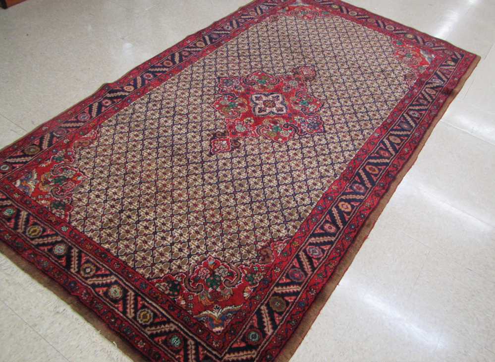 Appraisal: HAND KNOTTED PERSIAN CARPET featuring a central floral medallion on