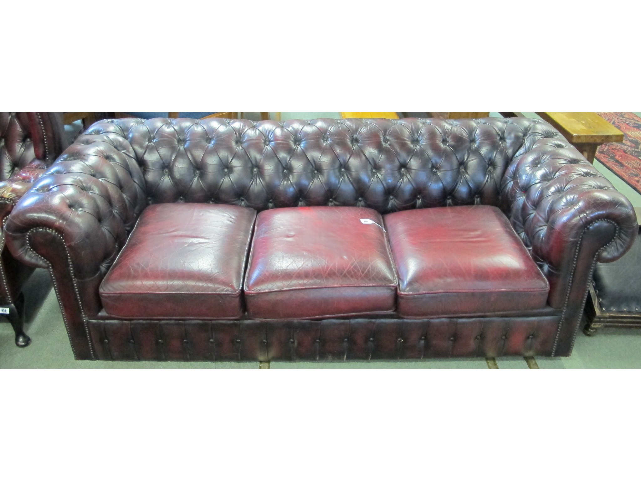 Appraisal: A red leather Chesterfield three seater sofa