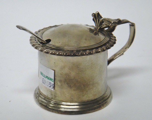 Appraisal: A silver hinge lidded mustard pot decorated with a gadrooned