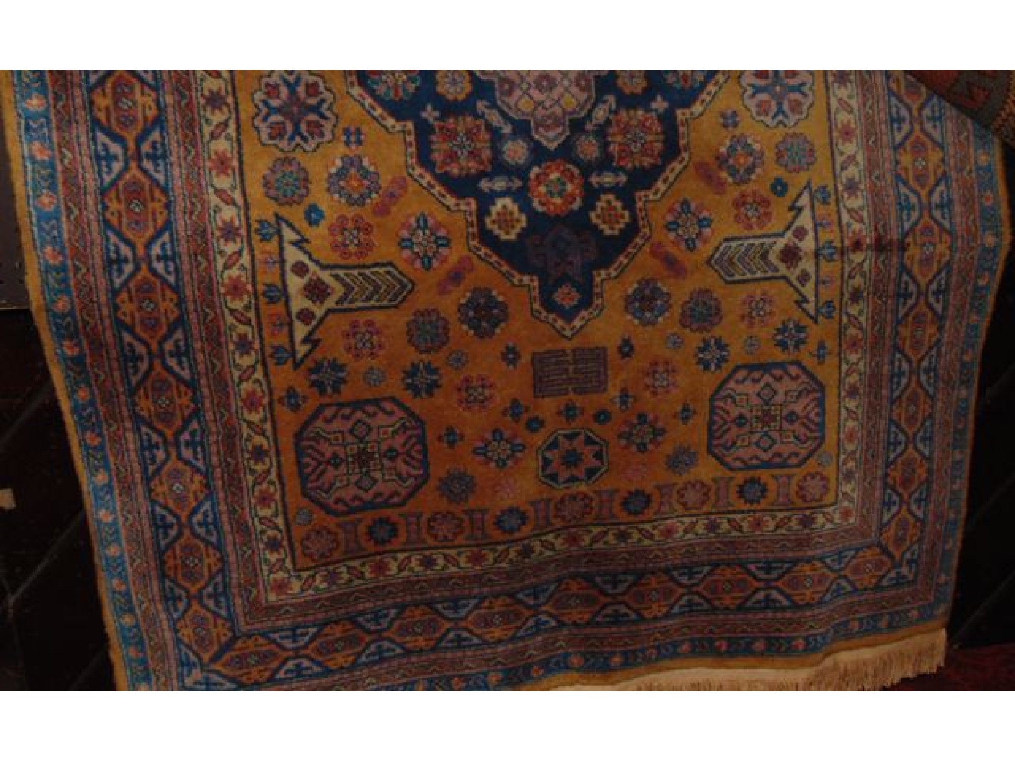 Appraisal: A Persian style wool rug with mustard ground field central