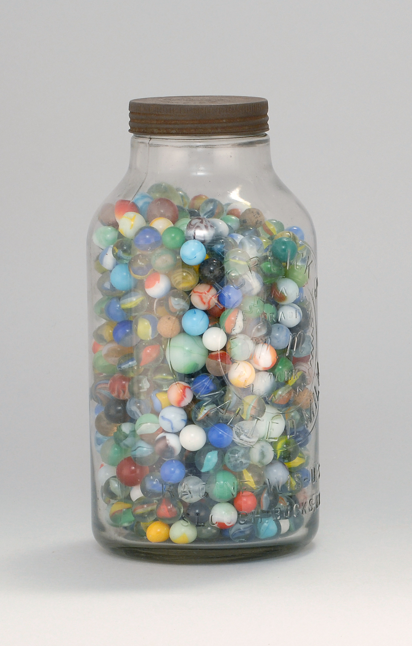 Appraisal: LARGE CLEAR GLASS JAR FILLED WITH GLASS MARBLES Marbles mostly