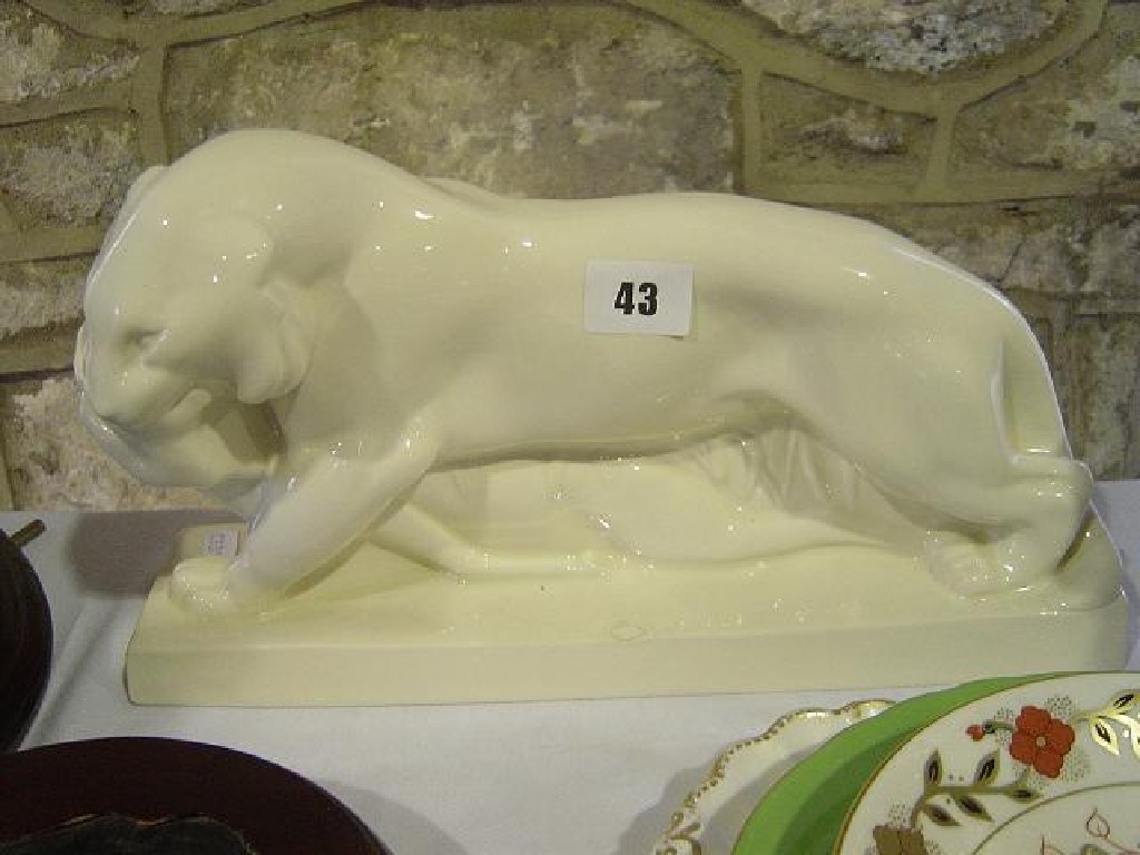 Appraisal: A cream glazed model of a prowling tiger dragging its