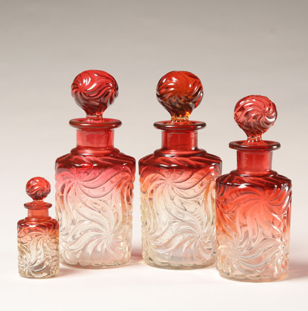 Appraisal: Four Baccarat amberina pressed glass bottles pinwheel pattern on bodies