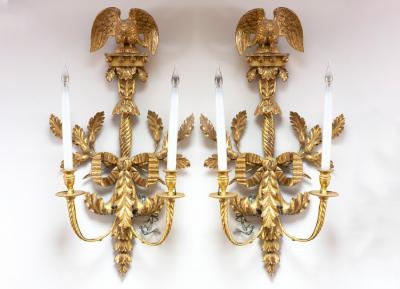 Appraisal: A pair of Empire style two-branch wall sconces with eagle