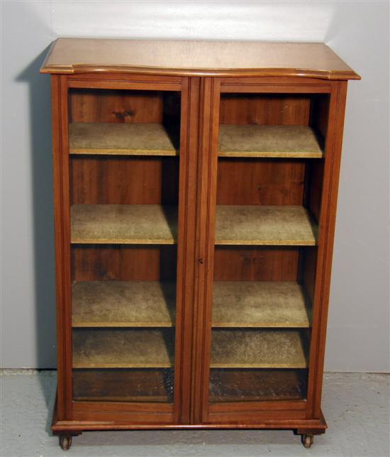 Appraisal: th century serpentine shaped mahogany glazed bookcase on castors h