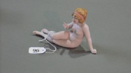 Appraisal: A bisque figure of a nude seated bathing beauty with