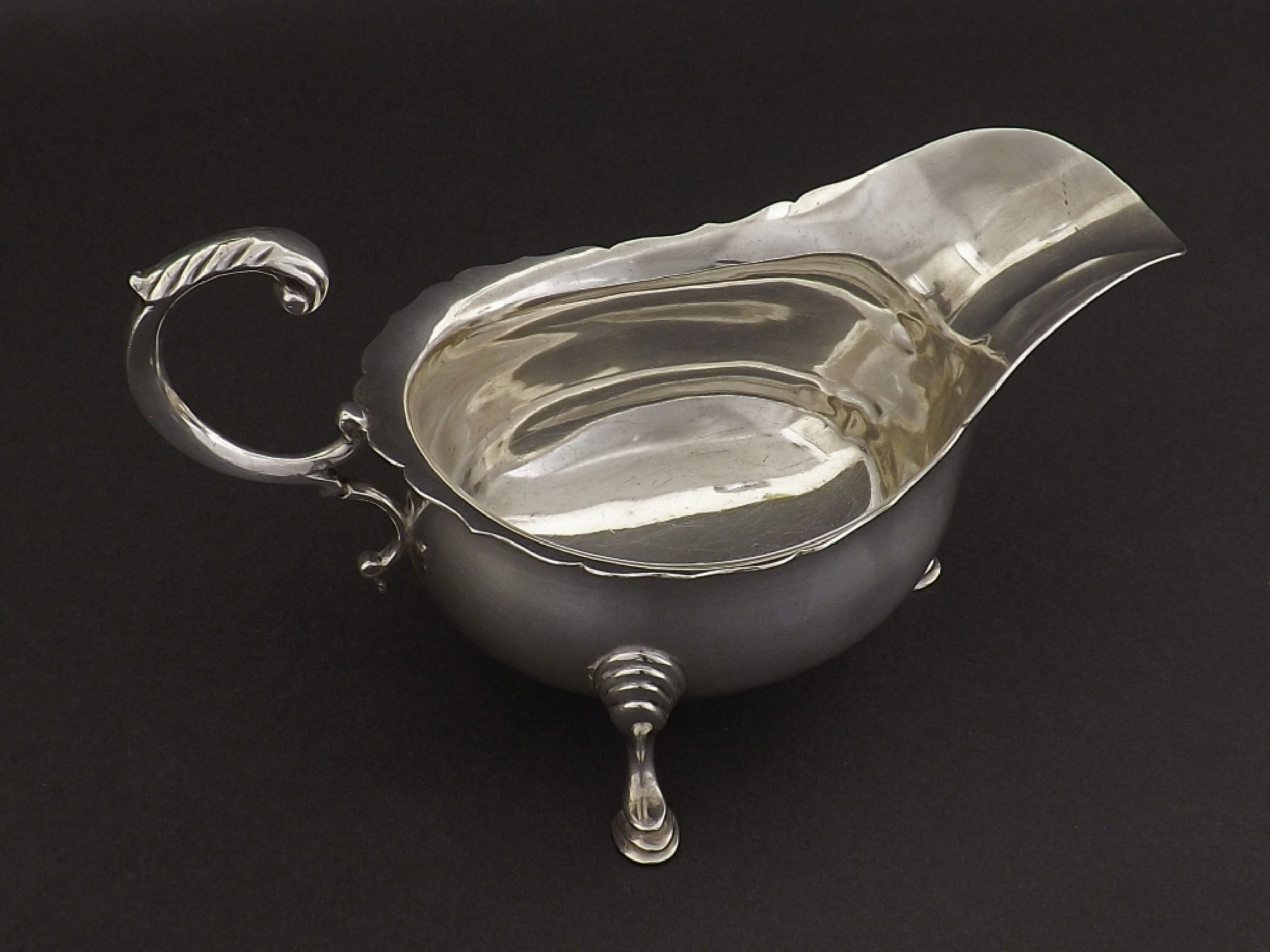 Appraisal: Georgian style s silver sauceboat with C-scroll handle and three