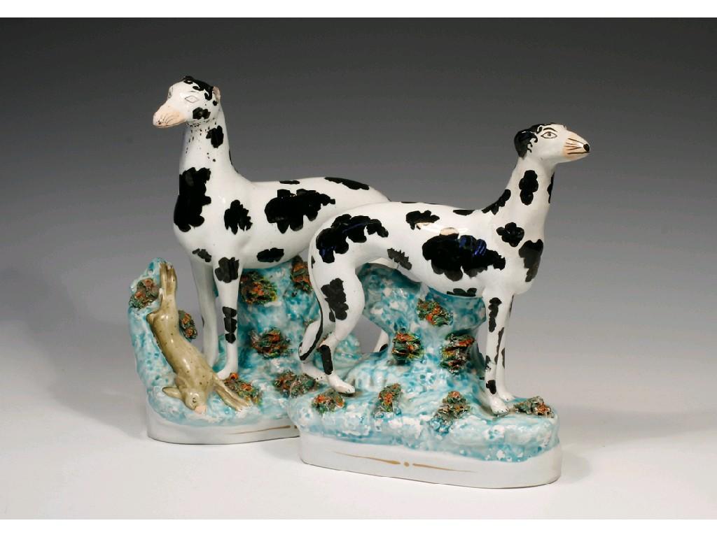 Appraisal: A PAIR OF STAFFORDSHIRE POTTERY GREYHOUNDS with naturalistically painted faces