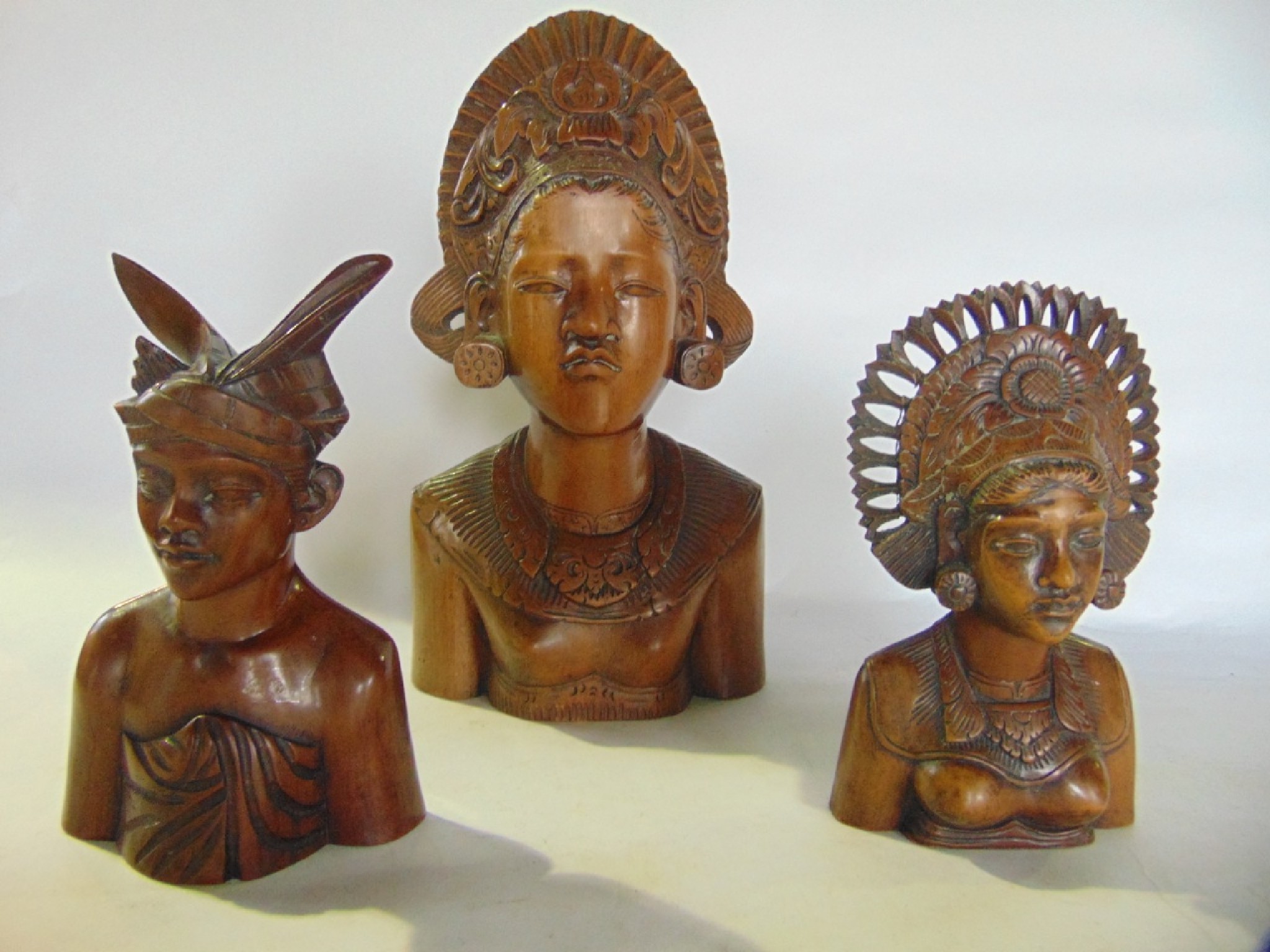 Appraisal: A trio of detailed shoulder length eastern carved figures the