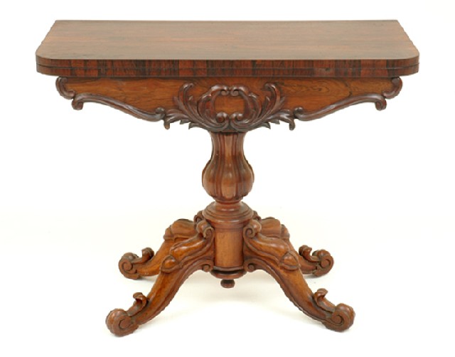 Appraisal: A VICTORIAN ROSEWOOD FOLDOVER TEA TABLE The figured top above