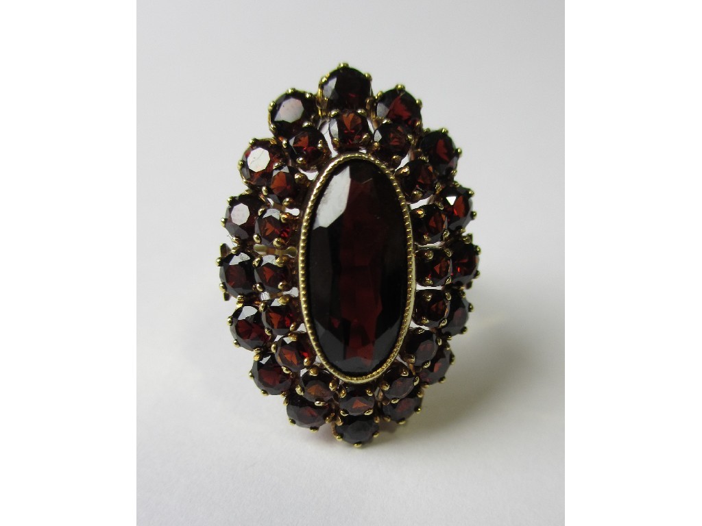 Appraisal: A fourteen carat gold garnet cluster ring with central milligrain