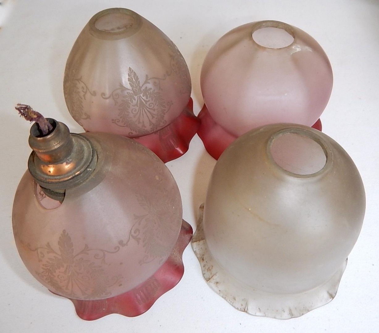 Appraisal: Four Edwardian satin glass lamp shades three with cranberry tinting