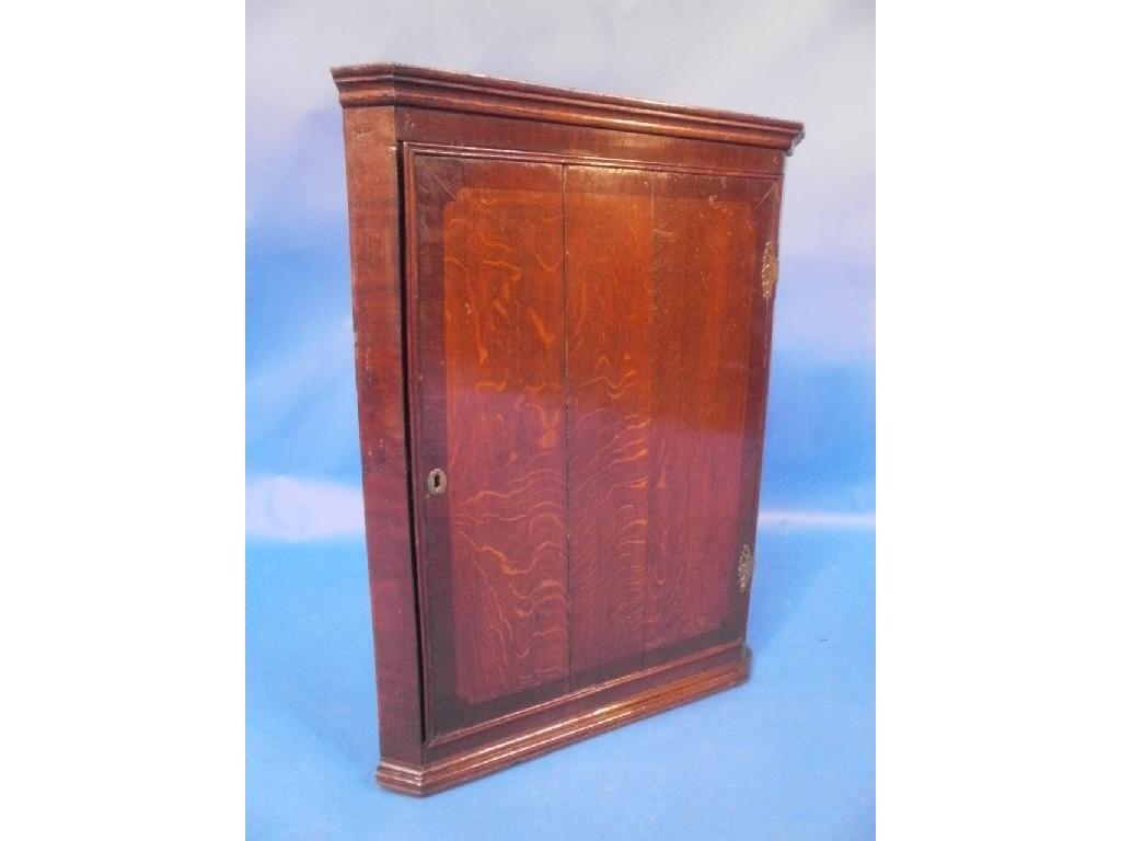 Appraisal: A George III oak hanging corner cupboard the single plank