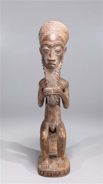 Appraisal: Seated African Fang carved wooden figure with intricate designs overall