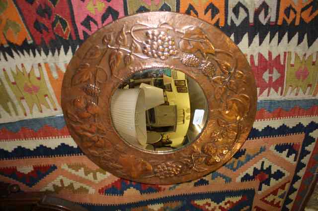 Appraisal: AN ARTS AND CRAFTS COPPER CIRCULAR WALL MIRROR with embossed