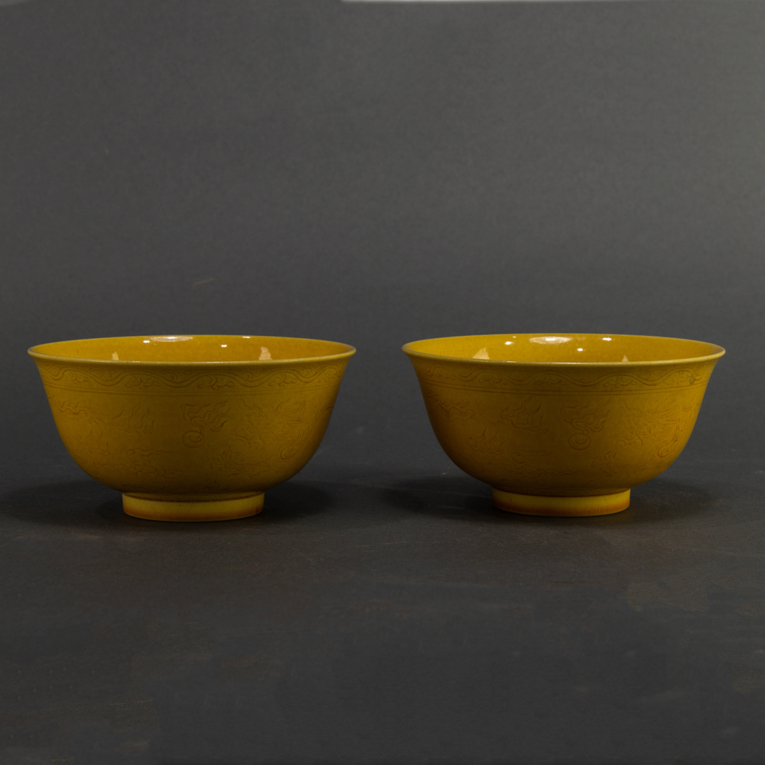 Appraisal: Pair of Chinese yellow glazed 'dragon' bowls each incise-decorated with