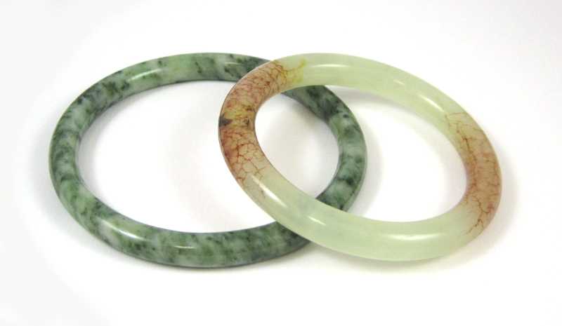 Appraisal: TWO ROUND JADE BANGLES including an opaque multi tone green