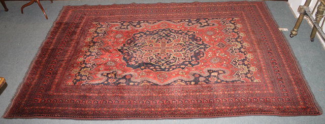 Appraisal: A PAKISTAN RED GROUND CARPET with central floral medallion and