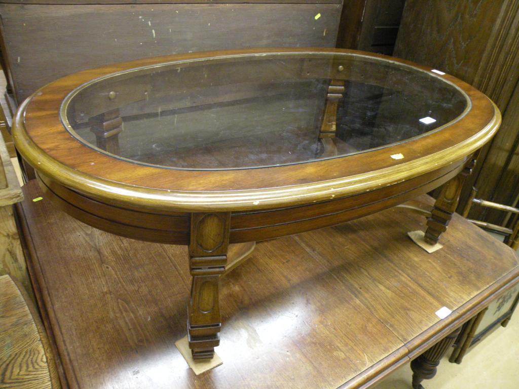 Appraisal: A modern walnut oval coffee table with a glass top