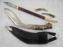 Appraisal: A Nepalese kukri in leather cased hardwood scabbard complete with